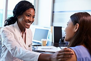 Doctor sitting and comforting woman