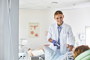 Gynecologist performing procedure with woman laying back