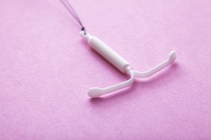 Photo of IUD device on pink background