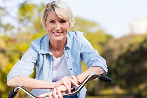 Senior woman in blue blouse on bike smiling