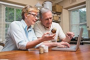 Senior couple researching prescriptions online telehealth