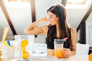 A healthy woman drinking citrus juice. Low immunity can harbor various gynecological issues in women.