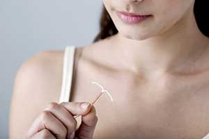 Woman holding a copper IUD