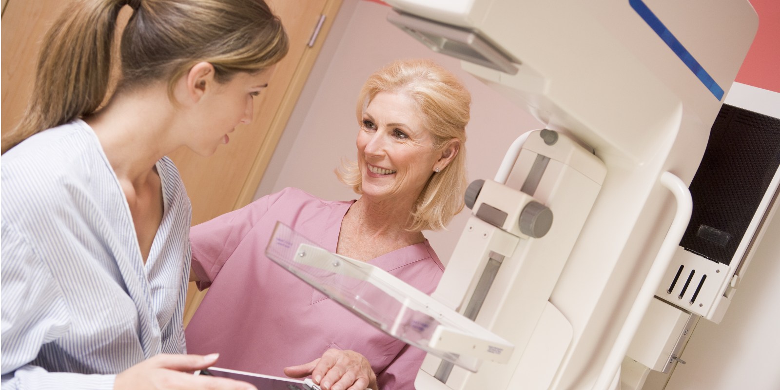 a nurse with a patient about to have a mammogram.
