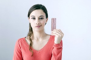 A young Raliegh woman holding contraceptive pill. Many women choose to get an IUD inserted by their doctor