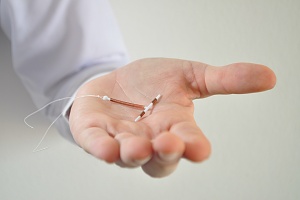 a doctor holding a IUD