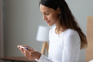 Woman checking her pregnancy test result. Nexplanon is a highly effective form of birth control