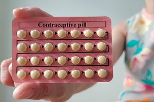 A woman shows birth control pill. Hormonal contraceptives can cause more pronounced side effects