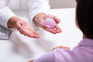 Gynecologist showing a type of barrier methods of contraception