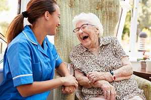 Nurse attending a Senior Woman Sitting In Chair