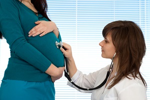 nurse practitioner inspecting pregnant woman on a light background