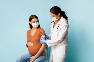 nurse practitioner vaccinating pregnant female patient