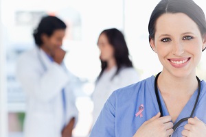 nurse standing wearing breast cancer awareness ribbon