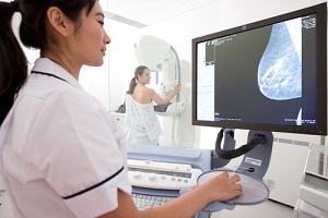 young adult woman taking the mammogram test on a machine knowing What To Expect From A Mammogram