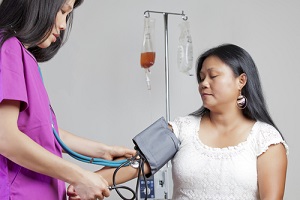 asian nurse taking blood pressure on asian patient during a GYN Wellness Screening