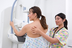 professional radiologist helping and attending a patient on a mammogram machine for breast care