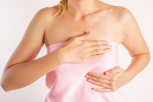 woman wearing a pink strapless checking her breast