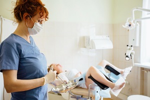 female doctor gynecologist performing an Pelvic Exam