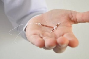 doctor holding a copper iud insertion device