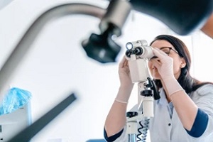 doctor looking into colposcopy device during procedure