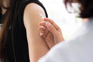 nurse using a syringe to inject the serum or vaccine to cure a patient