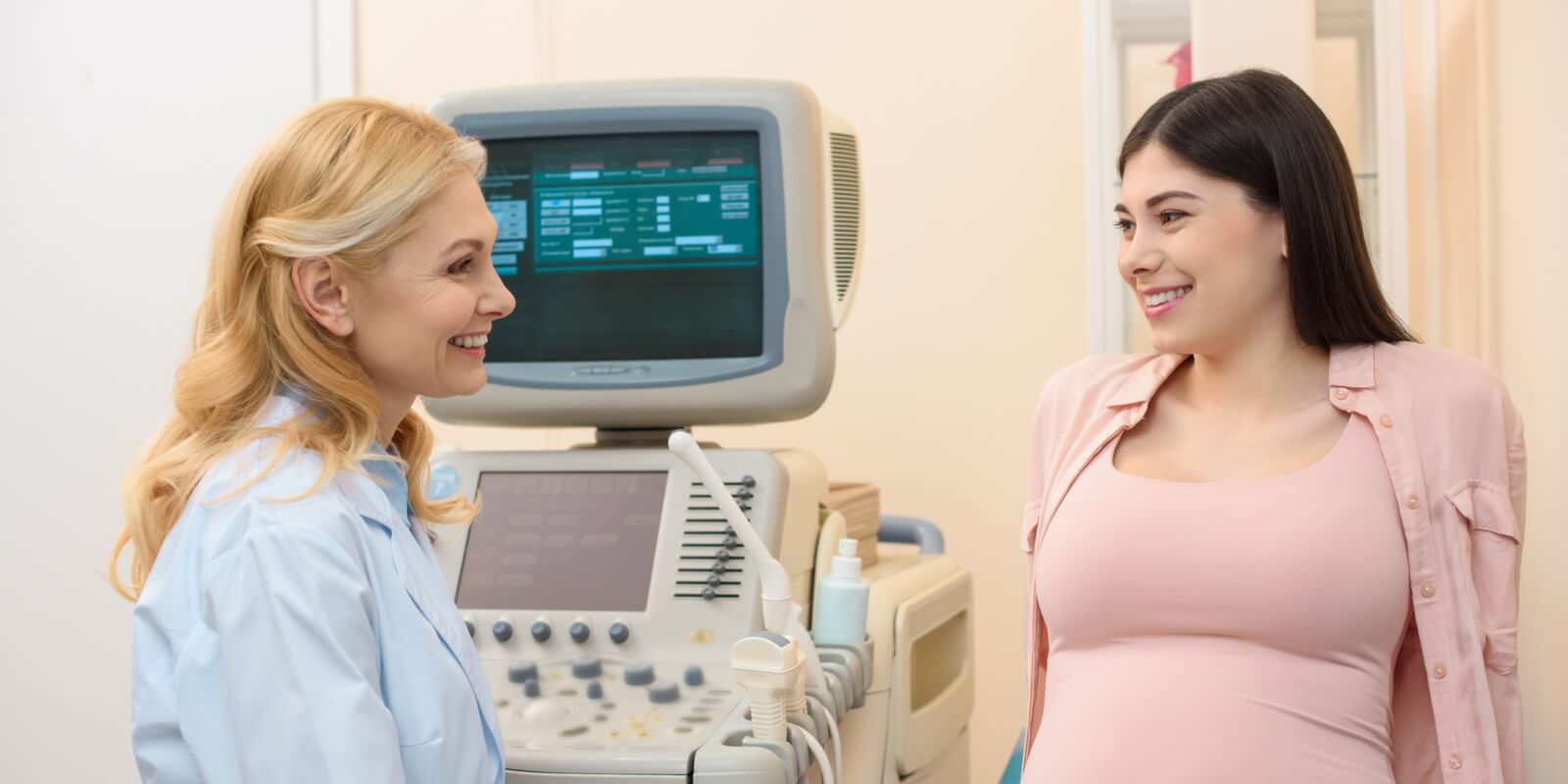 female obstetrician gynecologist consulting pregnant woman at ultrasound scanning office