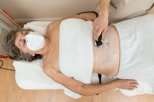 woman receiving radiofrequency stimulation treatment for faster recovery like for inflammations in pelvic floor