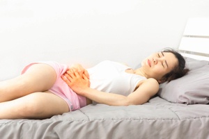 Woman lying on the bed facing pelvic floor dysfunction