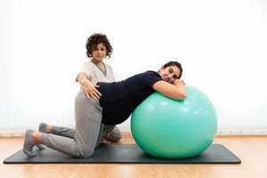 A pregnant woman with a therapist during pelvic floor therapy doing exercise