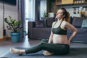 A woman is feeling pelvic pain while doing yoga