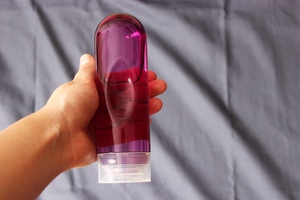 A woman holding a bottle of sex lubricants