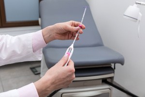 A doctor holding an IUD after the removal