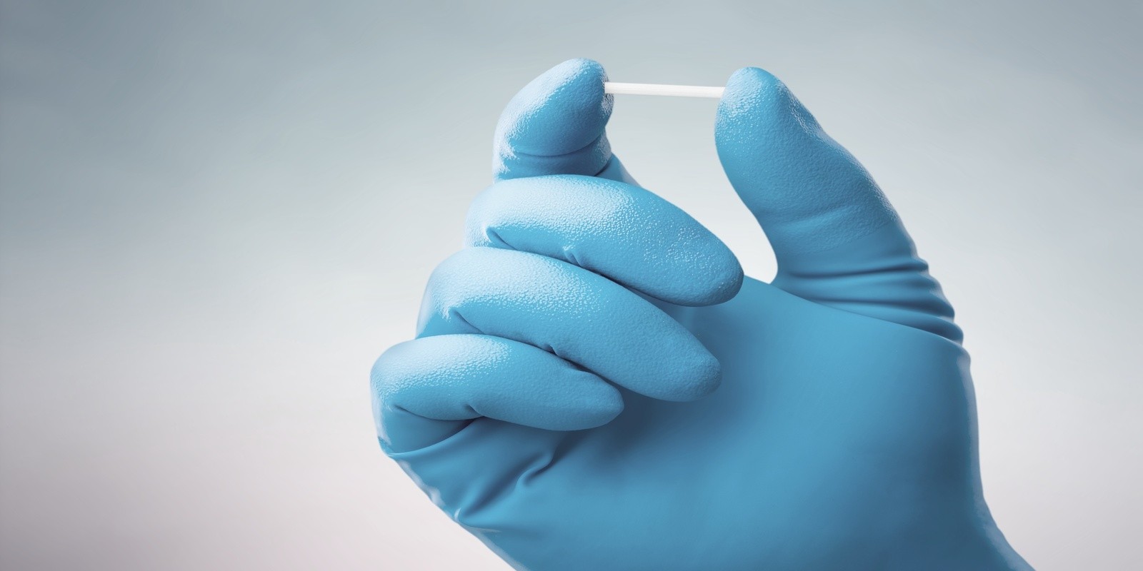 A hand holding a Nexplanon birth control arm implant