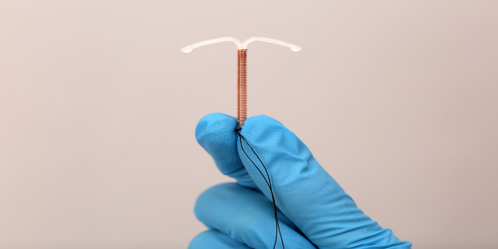 A hand holding an IUD