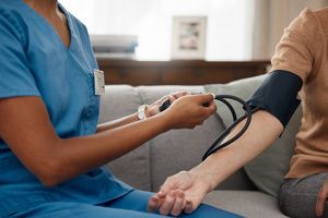 A nurse checking the blood pressure of a woman