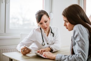 A female doctor educating a woman about IUD