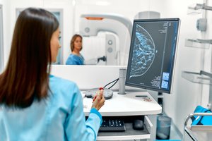 A doctor checking mammograms of a woman in an LED screen, breast cancer