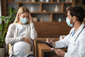 A pregnant woman feeling dizziness is consulting her doctor