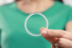 women in green shirt holding vaginal ring