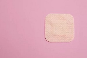 a birth control patch on pink background