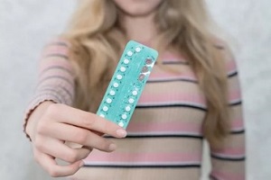 women holding birth control pill