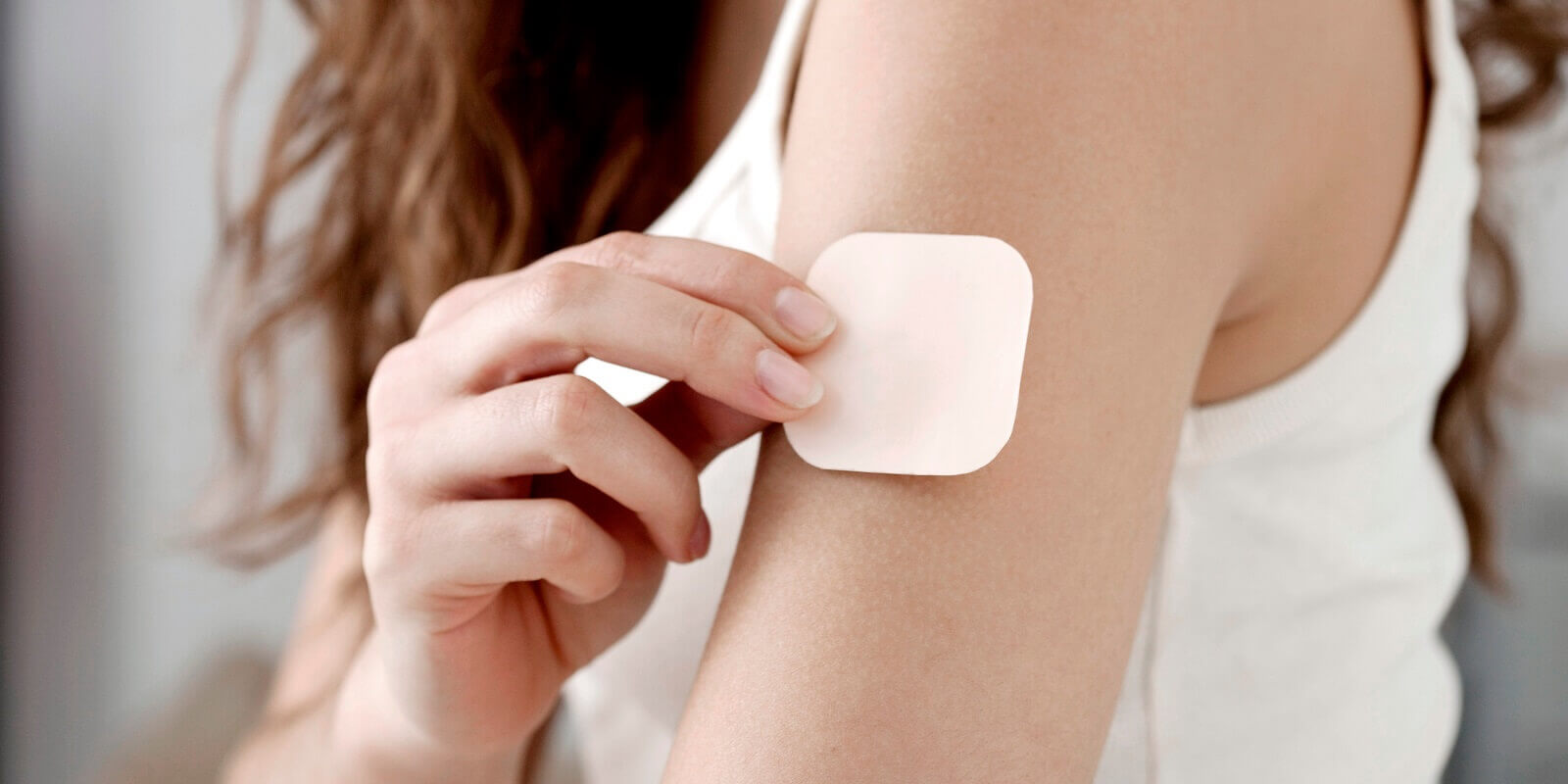 woman putting on contraception patch