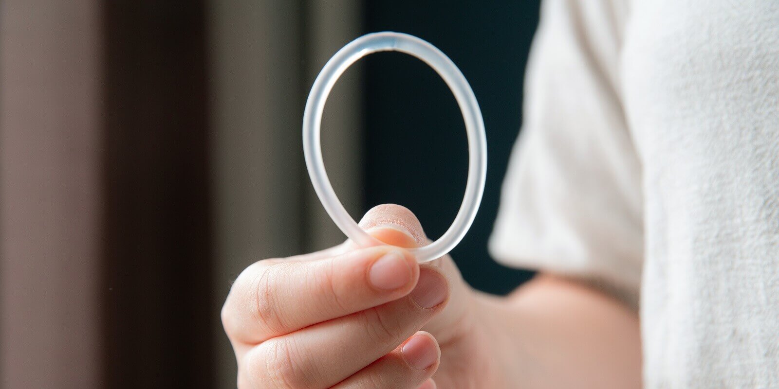 woman hand holding a birth control ring