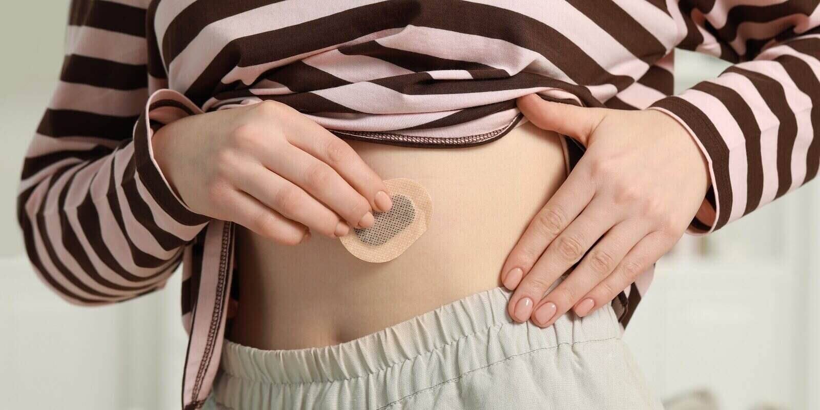 NC woman applying contraceptive patch onto her belly
