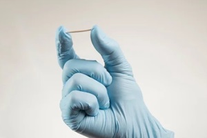 Raleigh OBGYN hand in rubber gloves holding a hormonal implant