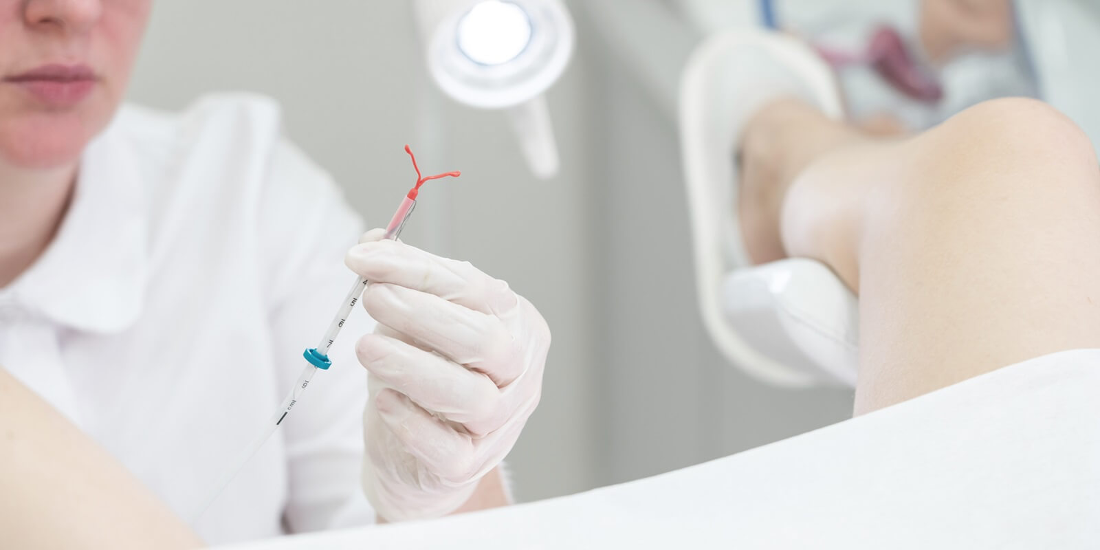 gynecologist holding an IUD birth control device before using it for patient