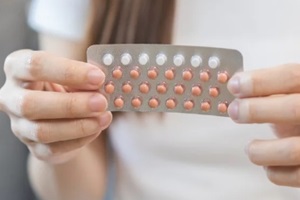 pregnancy, menstruation concept, birth control pills asian young woman hand holding hormonal oral contraceptive medicine