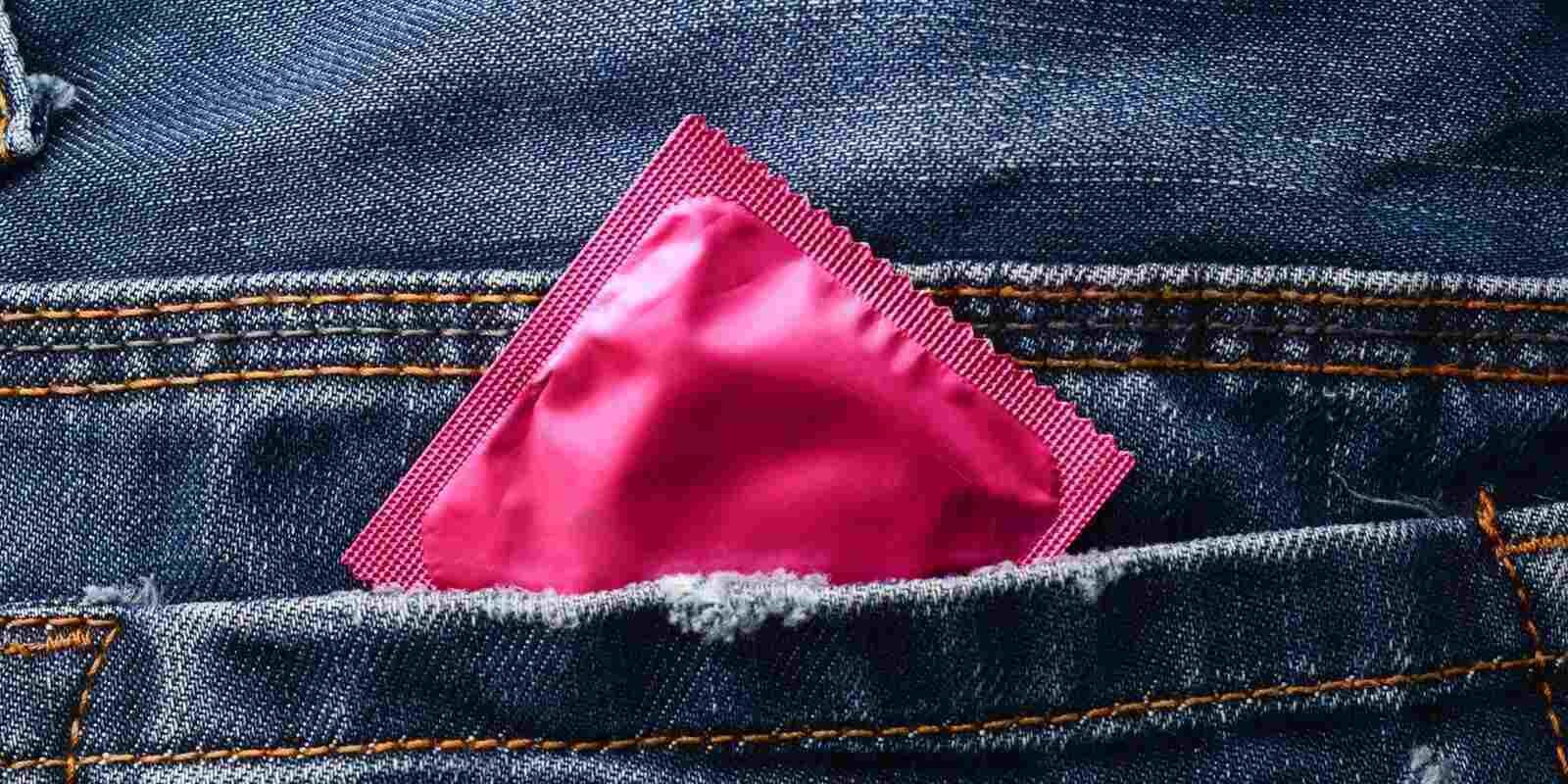 pink condom in the pocket of blue jeans
