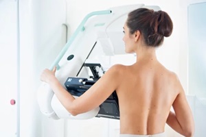 healthy young woman doing cancer prophylactic mammography scan at hospital