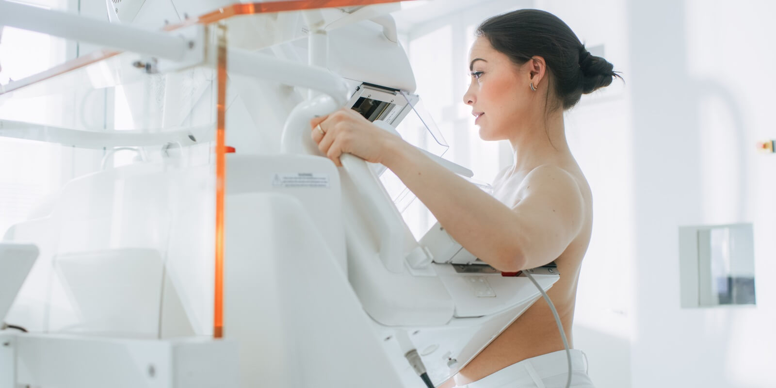 portrait shot of topless female patient undergoing mammogram screening procedure in Raleigh, NC